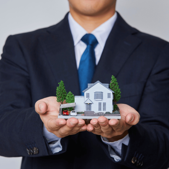 agente inmobiliario casa velaris con una casa de papel en las manos