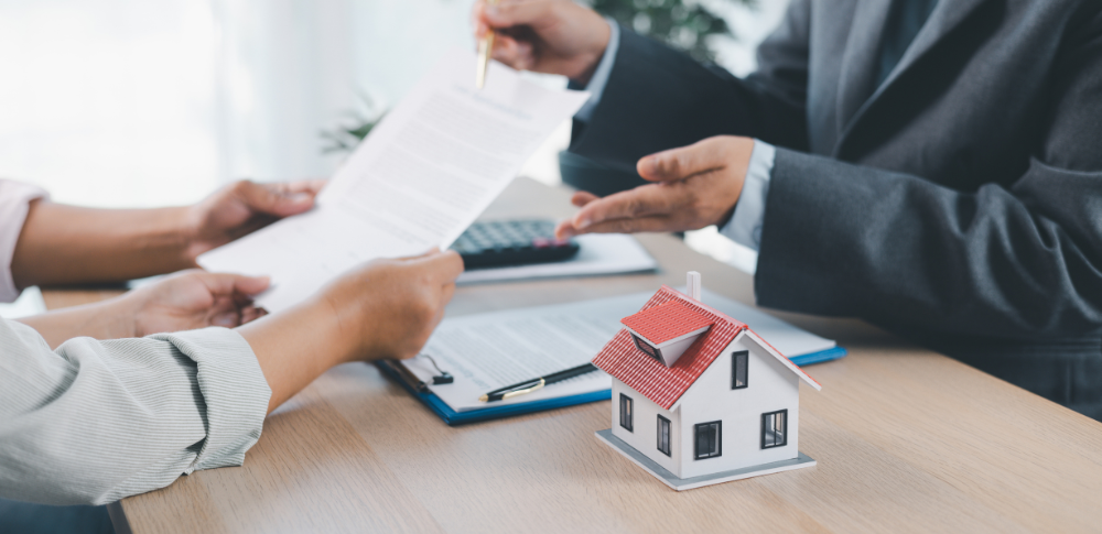 Personas revisando un contrato de vivienda sobre una mesa